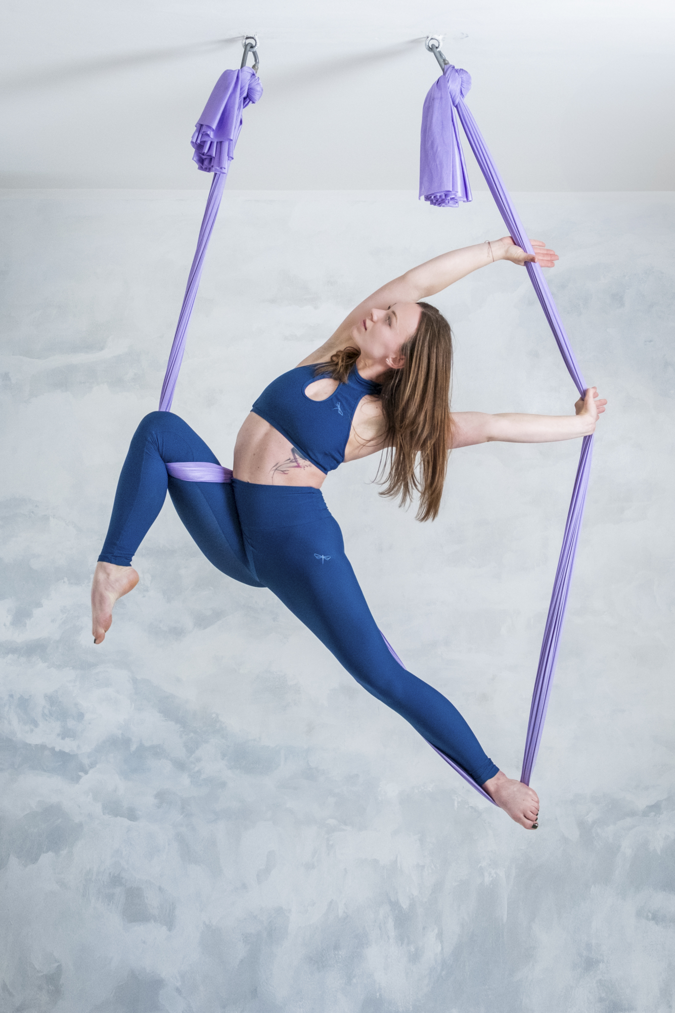 Cvičenka v akrobatickém úchopu na visuté šále aerial hammock v Polegymu Kladno