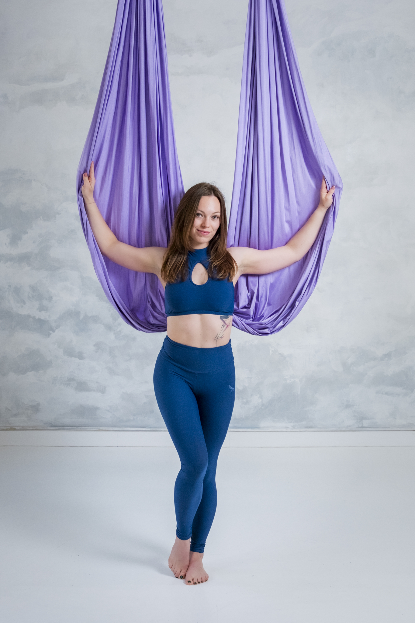 Dospělá cvičenka v závěsných šálách aerial hammock v Polegymu Kladno